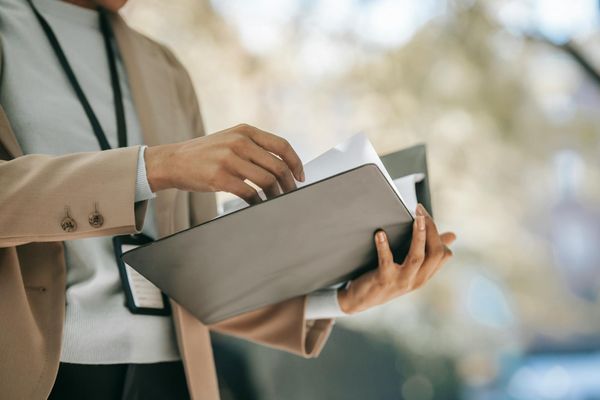 A woman flipping through papers in a folder | Source: Pexels