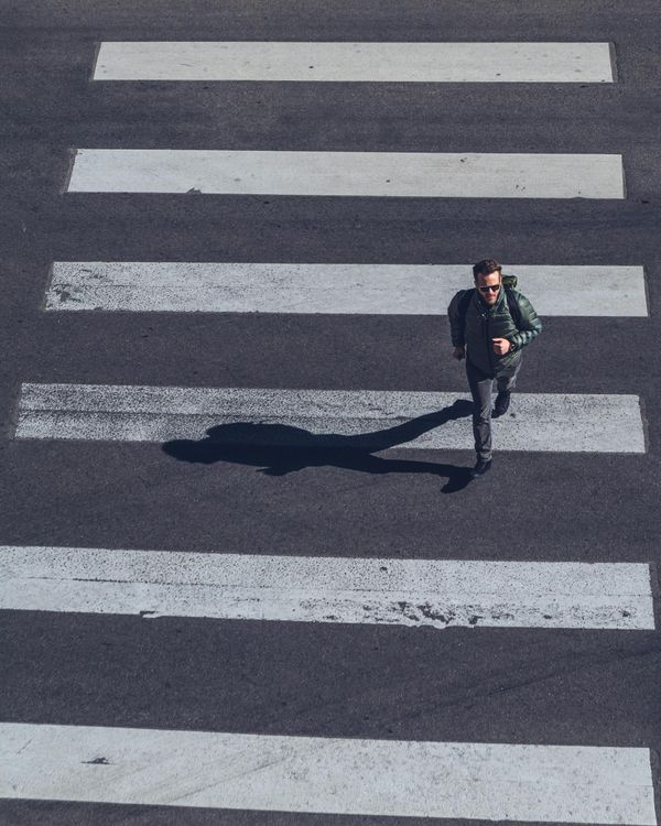 A man hurrying over a crosswalk | Source: Pexels