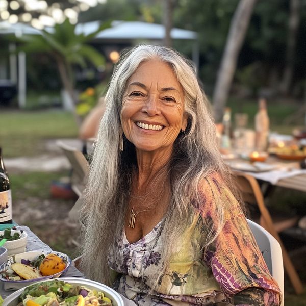 A smiling older woman sitting at a table